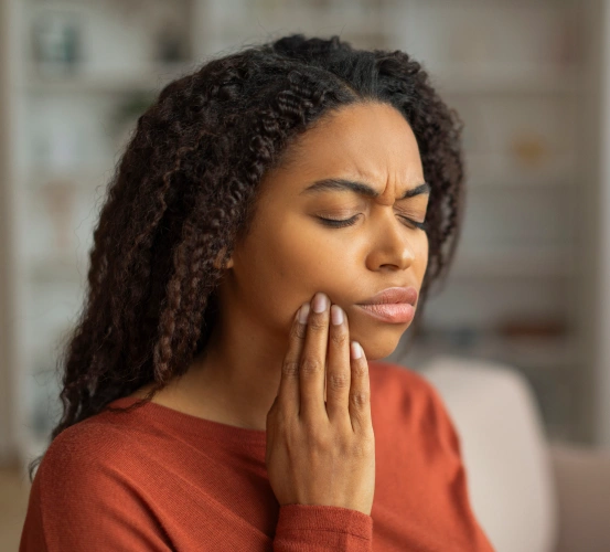 Woman holding her jaw in pain from a toothache